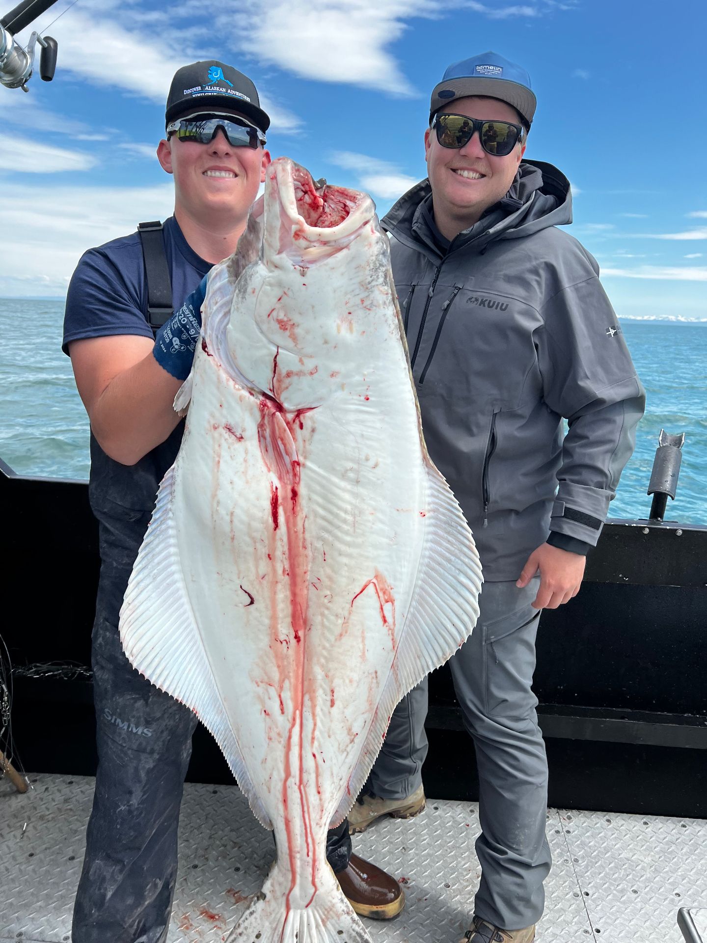 Guests holding a massive halibut catch